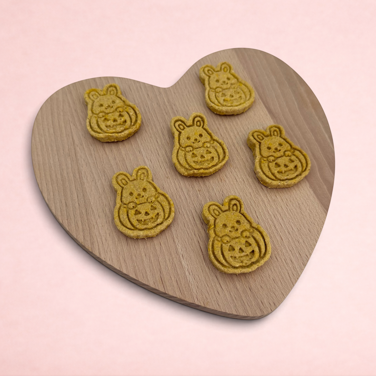 Darling Bun Shop handmade pumpkin bunny oat treats for small animals on a heart-shaped wooden board