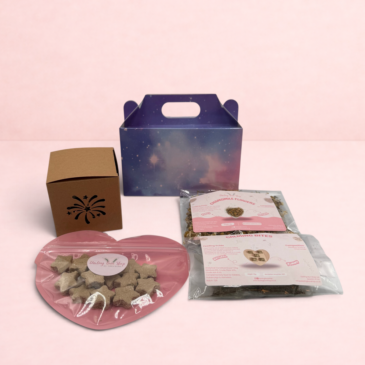 Darling Bun Shop Calming Bonfire Box with star-shaped treats, chamomile flowers, and firework-themed enrichment toys.