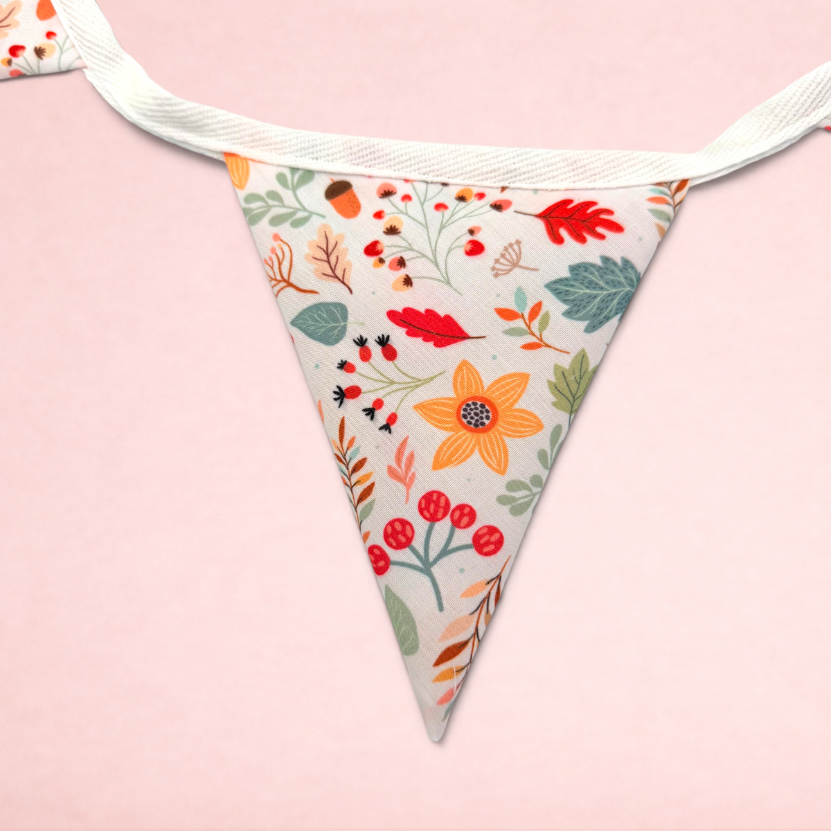 Darling Bun Shop bunting featuring a colourful autumn pattern of acorns, oak leaves, and flowers on white fabric.