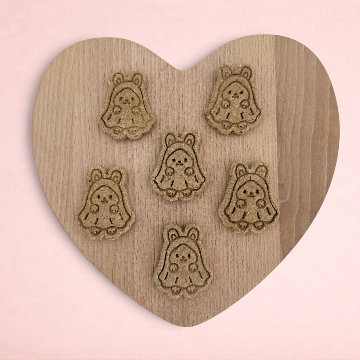 Darling Bun Shop handmade banana and oat ghost bunny Halloween treats for small animals on a wooden heart board.