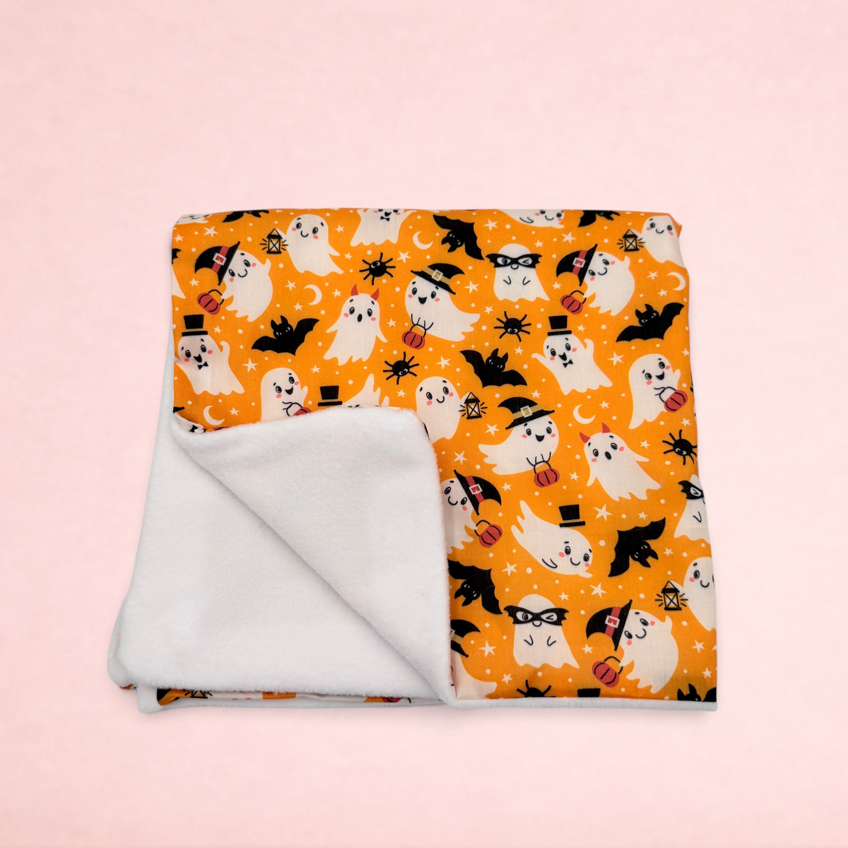 Darling Bun Shop Hoppy Haunting blanket with orange Halloween ghost print and soft white fleece lining