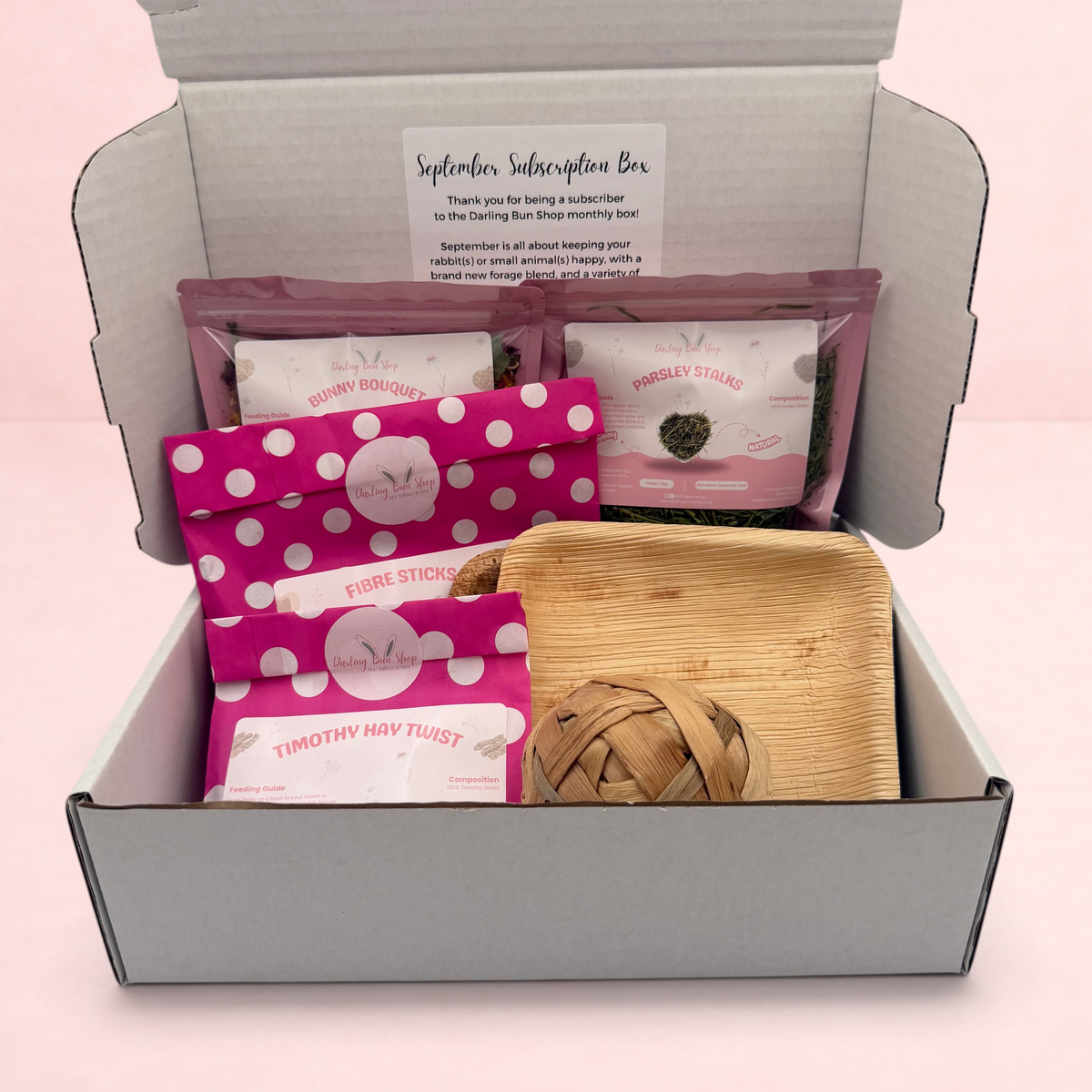 Darling Bun Shop September subscription box for rabbits containing forage treats, fibre sticks, and a wooden bowl.
