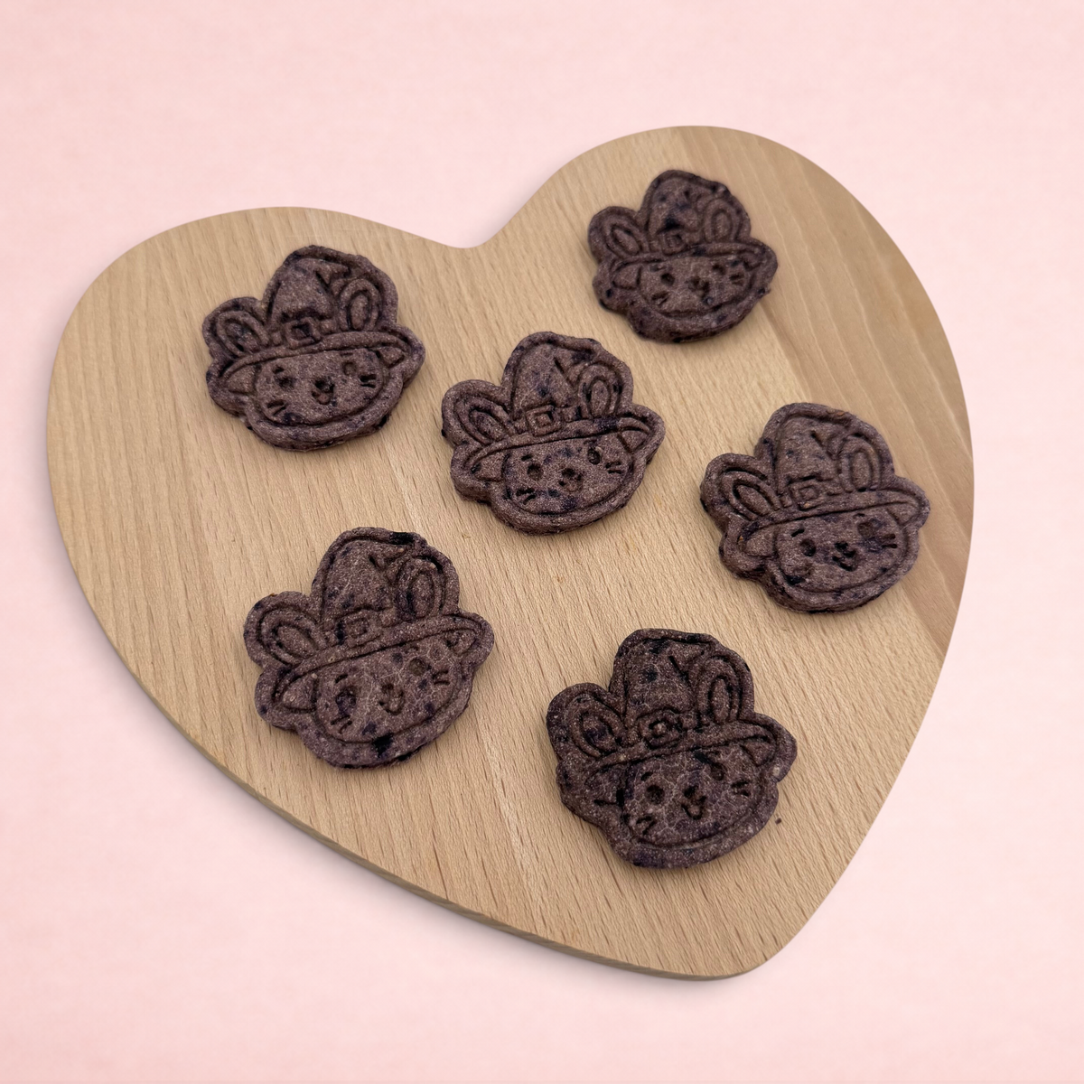 Darling Bun Shop handmade blueberry and oat bunny-shaped Halloween treats for small animals on a heart-shaped board.