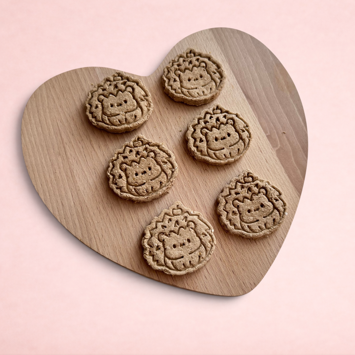 Darling Bun Shop handmade banana and oat hedgehog-shaped treats for small animals on a wooden heart board