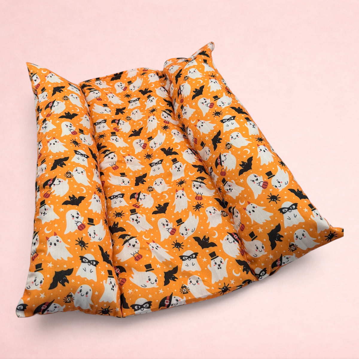 Darling Bun Shop Hoppy Haunting Snuggle & Flop Bed in orange with a cute ghost, bat, and pumpkin Halloween pattern.