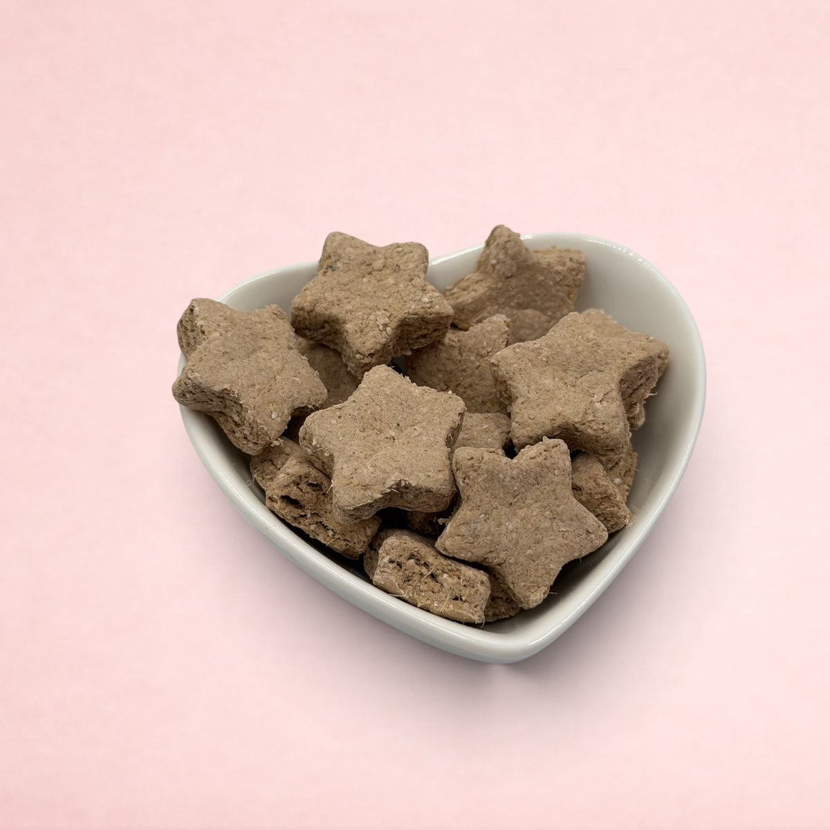 Darling Bun Shop calming banana and lavender oat star treats for rabbits in a white heart-shaped bowl