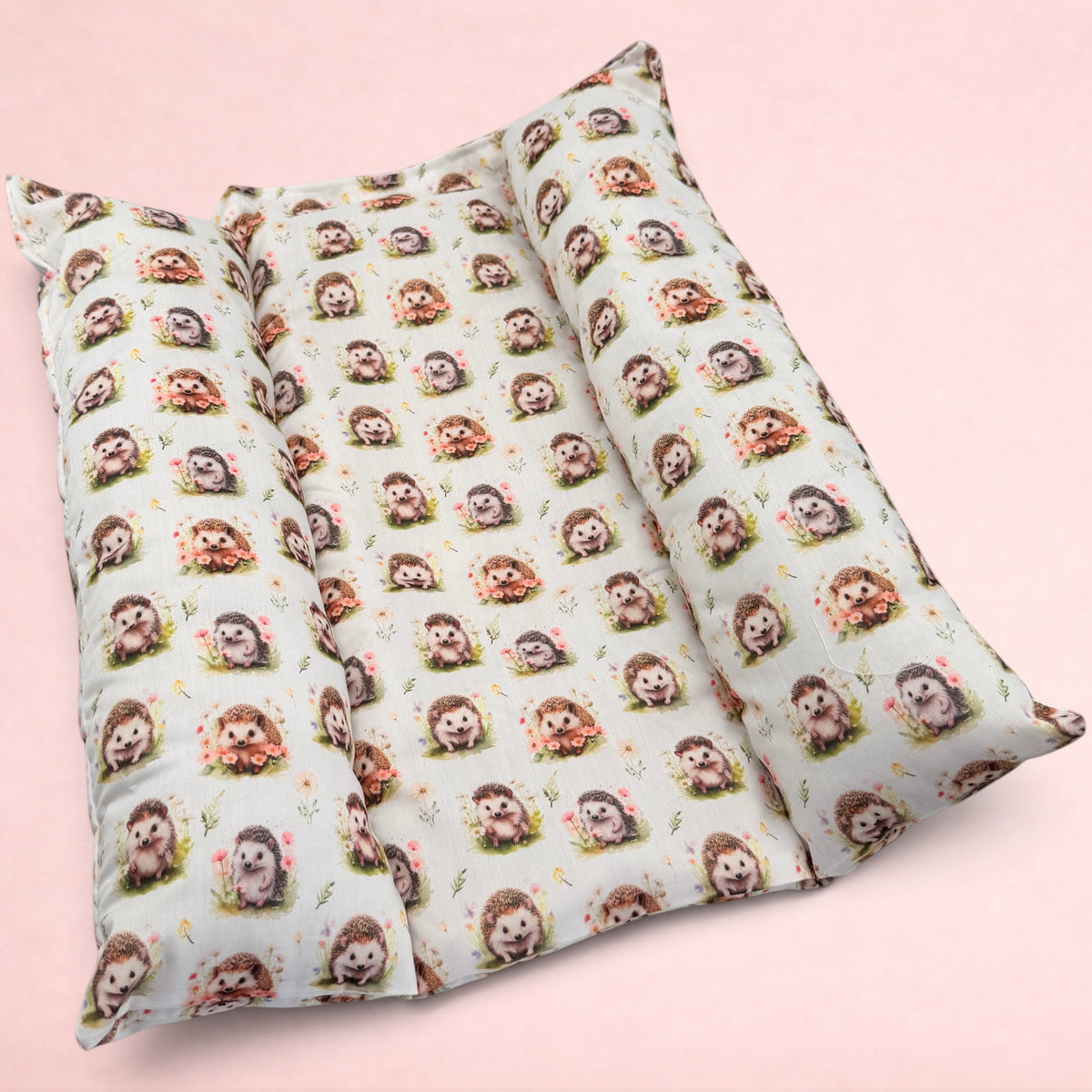 Darling Bun Shop Autumnal Hedgehogs Snuggle & Flop Bed with raised sides for rabbits in a soft cream fabric print.