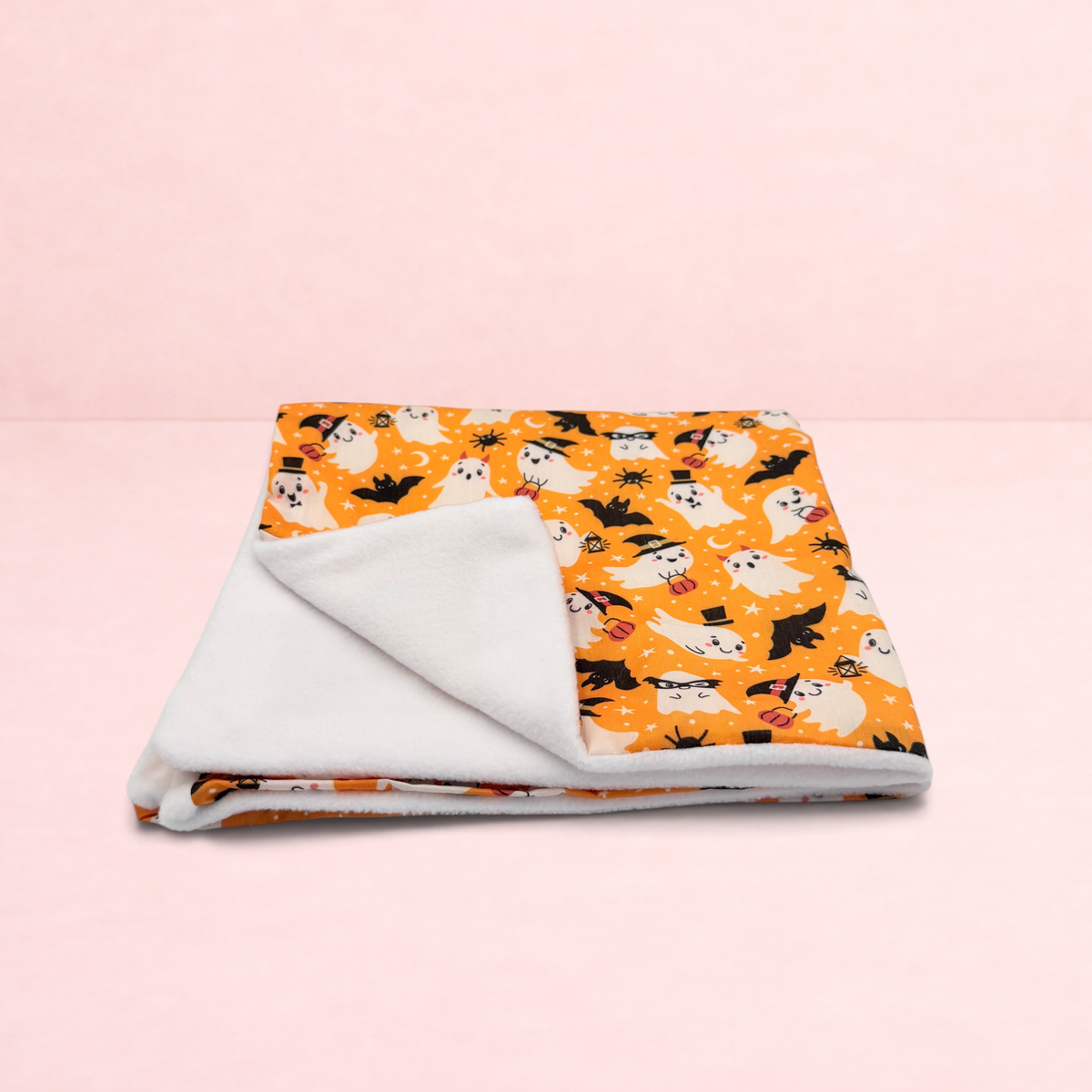 Darling Bun Shop Hoppy Haunting blanket with orange ghost and bat Halloween print and soft white fleece lining