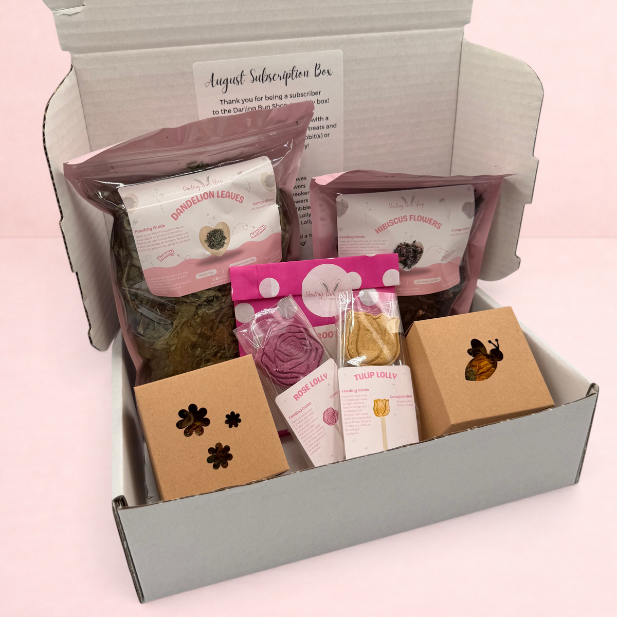 Darling Bun Shop August subscription box for rabbits containing dried flowers, herbal treats, and boredom breakers.