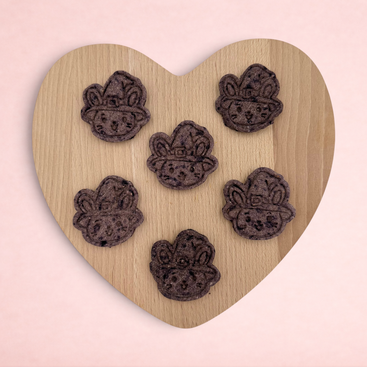 Darling Bun Shop handmade blueberry oat witch bunny treats for small animals arranged on a wooden heart board
