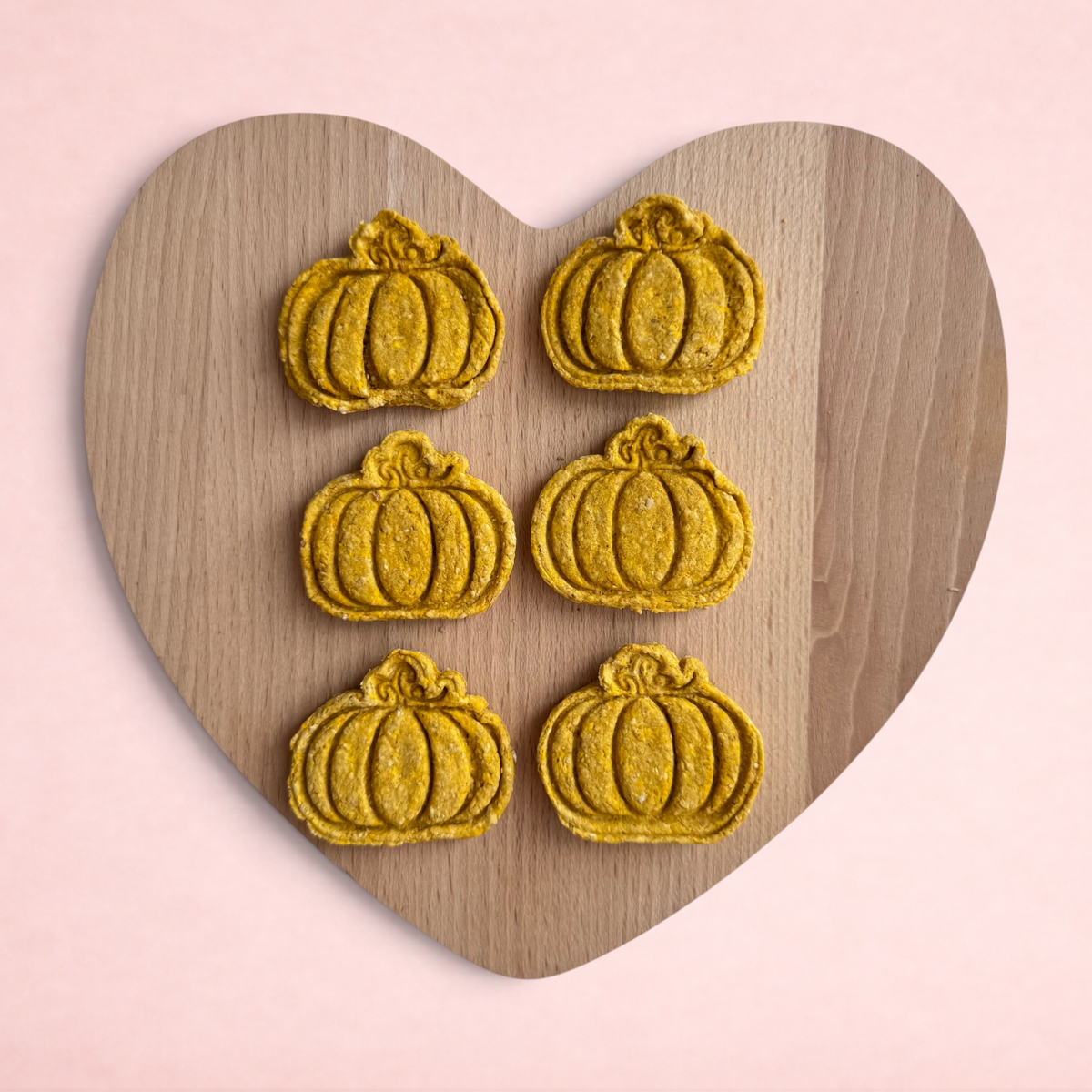 Darling Bun Shop handmade pumpkin-shaped oat treats for rabbits on a wooden heart board