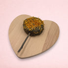 Darling Bun Shop hay-based marigold lolly treat for small animals with an apple wood stick on a heart-shaped board