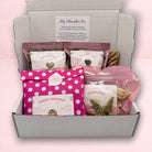 Darling Bun Shop July subscription box for rabbits containing assorted natural forage, treats, and enrichment toys.