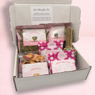 Darling Bun Shop June subscription box for rabbits containing assorted natural treats, hay pellets, and a carrot toy.