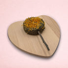 Darling Bun Shop hay-based marigold lolly treat with apple wood stick for small animals on a heart-shaped board